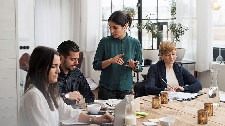 Group meeting with female manager giving direction to her associates.